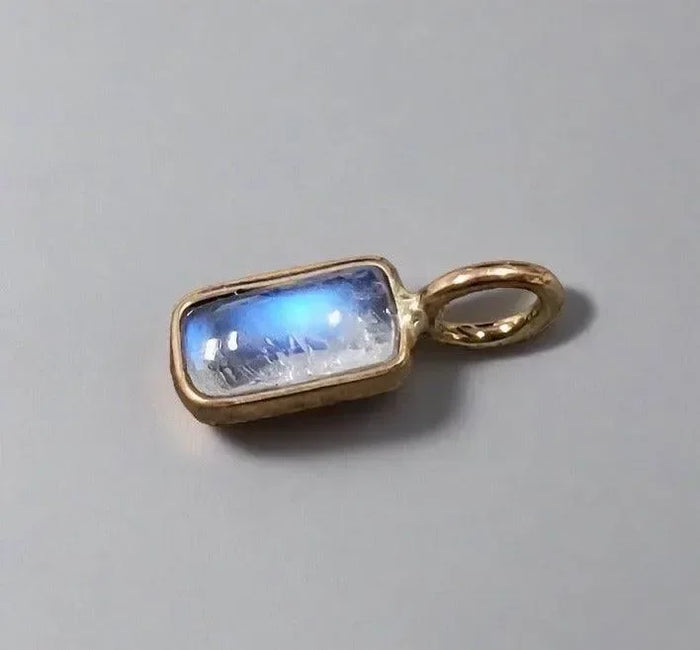 Gold pendant with glowing blue moonstone, elegant jewelry accessory