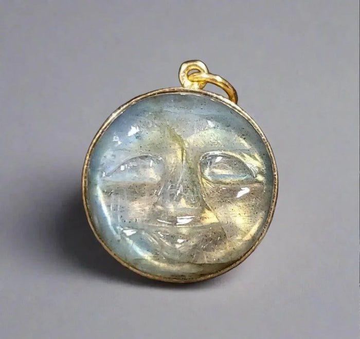 Gold pendant with carved moon face in iridescent stone, elegant jewelry accessory