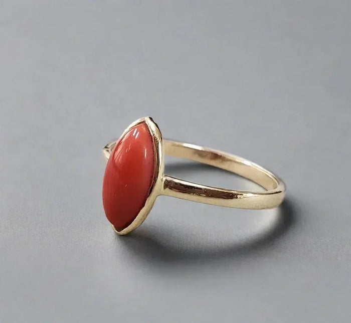 Gold ring with oval red coral stone, elegant jewelry accessory