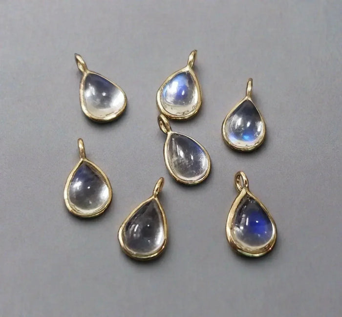 Teardrop moonstone pendants in gold settings, elegant jewelry accessories with blue sheen