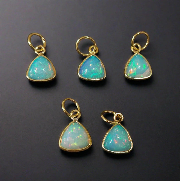 Five gold opal pendants with iridescent blue-green stones, elegant jewelry accessories