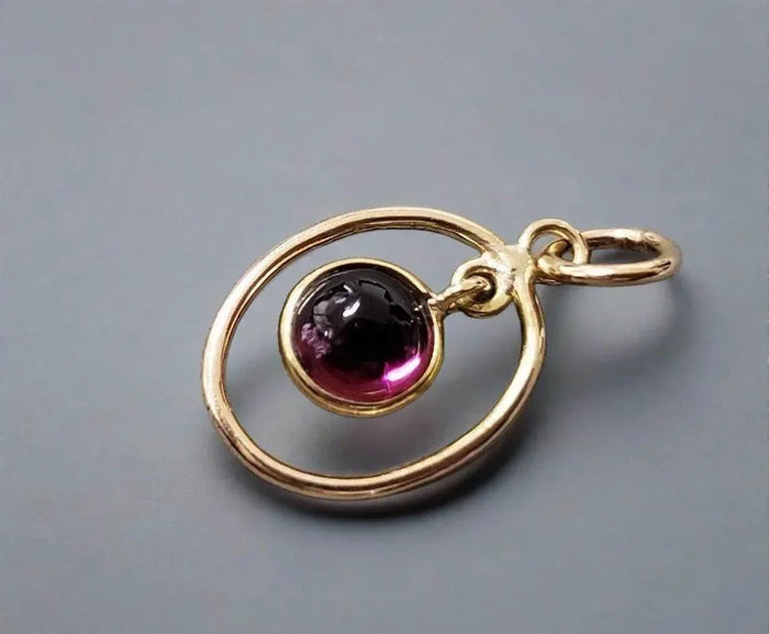 Gold pendant with round purple gemstone, elegant jewelry accessory