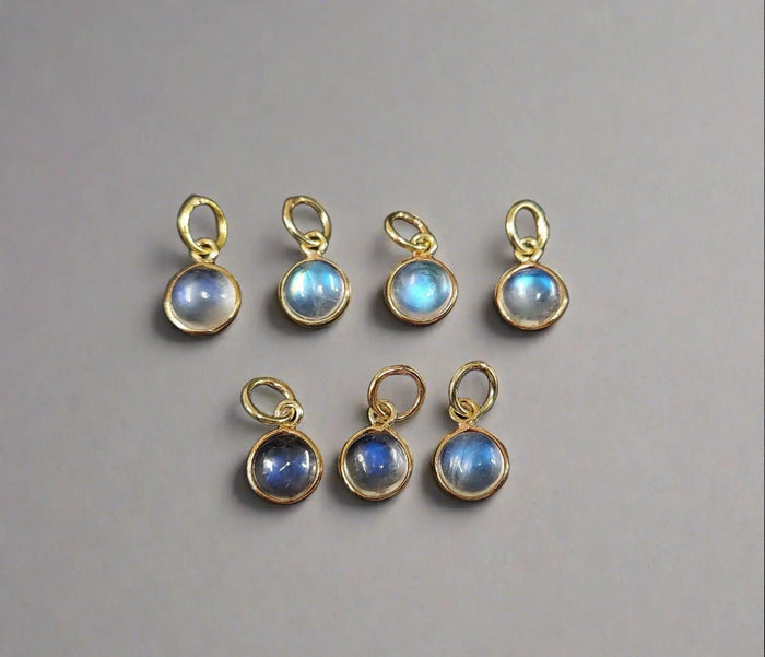 Gold-plated moonstone charms with blue adularescence, ideal for elegant jewelry making