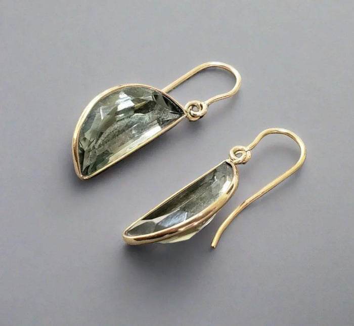 Elegant gold drop earrings with faceted green gemstones, perfect for sophisticated jewelry lovers.