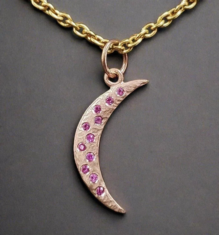 Gold crescent moon pendant necklace with pink gemstones, elegant jewelry accessory