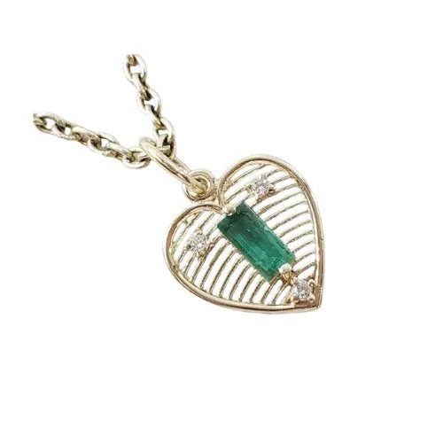 Heart-shaped gold pendant with emerald & diamonds on chain, elegant jewelry accessory