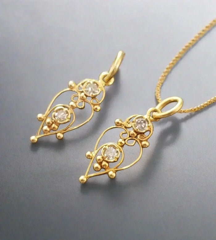 Elegant gold pendant with diamond accents, intricate filigree design, perfect for sophisticated jewelry lovers