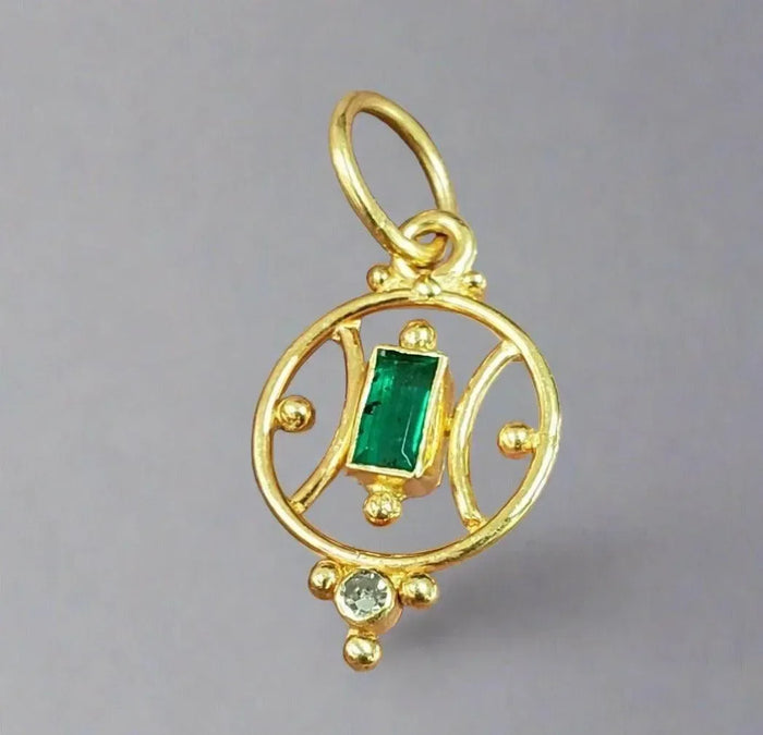 Elegant gold pendant with emerald and diamond accents, perfect for luxury jewelry lovers