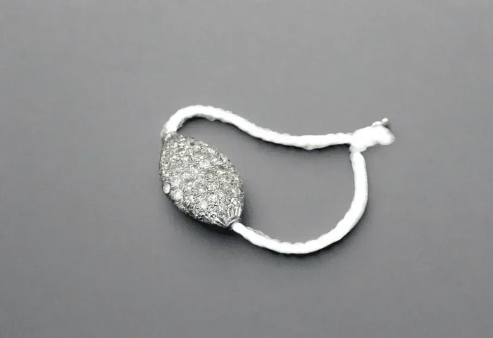 Elegant diamond-encrusted pendant on a white cord, showcasing sophistication and luxury.