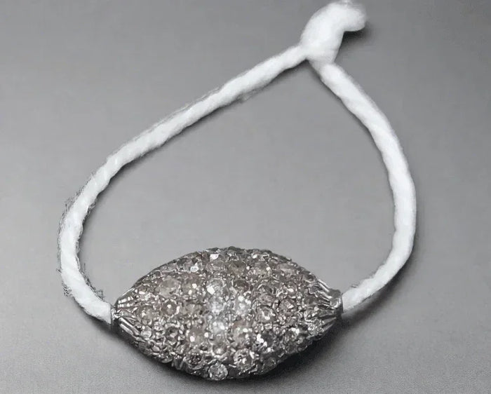 Elegant diamond-encrusted pendant on white cord, showcasing luxury jewelry design