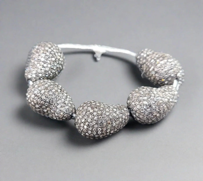 Elegant diamond-encrusted bangle bracelet with sparkling pavé stones, perfect for luxury jewelry lovers.