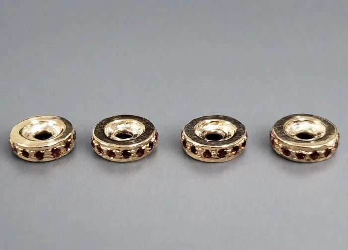 Gold-toned beads with red gemstone accents, ideal for elegant jewelry making and DIY accessories.
