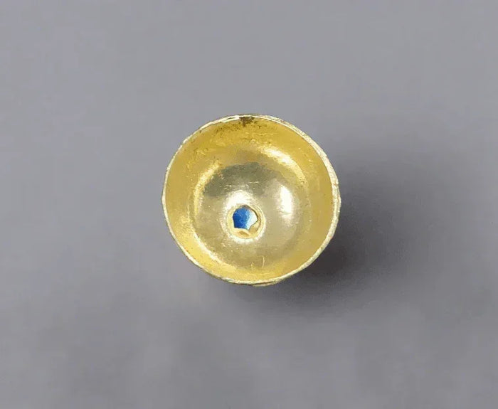 Golden jewelry component with blue gemstone center, elegant and sophisticated design