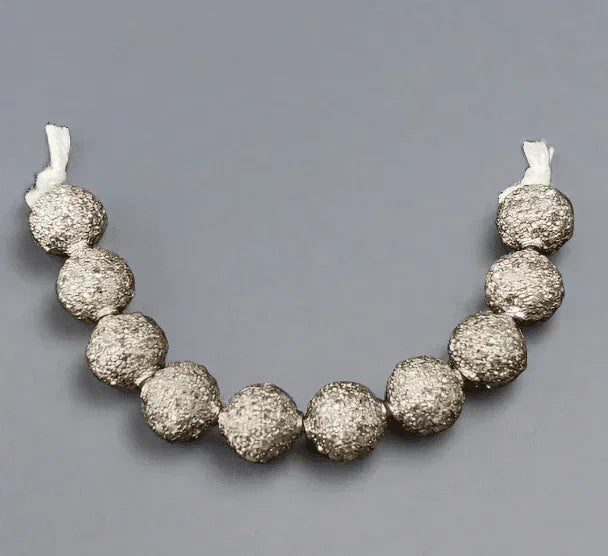 Textured silver bead necklace with elegant round beads and white cord ends