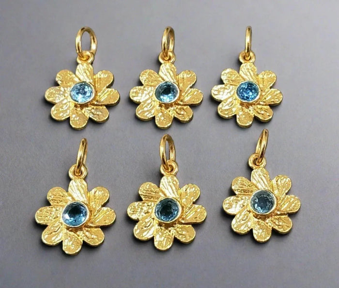 Gold flower charms with blue gemstone centers, elegant jewelry accessories