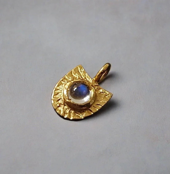 Gold pendant with blue gemstone, textured design, elegant jewelry accessory