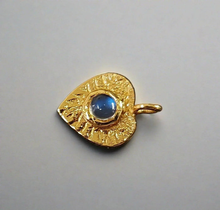 Gold evil eye pendant with blue gemstone, textured design for elegant jewelry collection