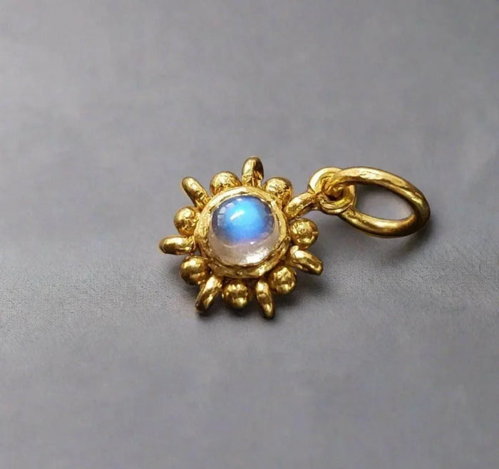 Gold sunburst charm with glowing moonstone, elegant jewelry accessory