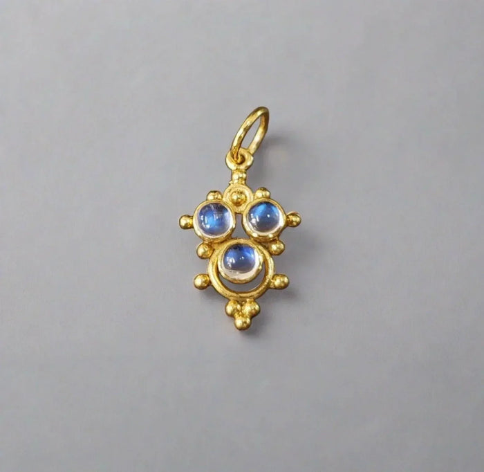 Gold pendant with three blue gemstones, elegant jewelry accessory