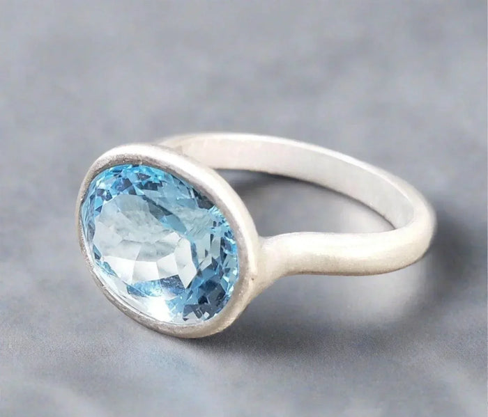 Elegant silver ring with oval blue topaz gemstone, minimalist design for everyday wear