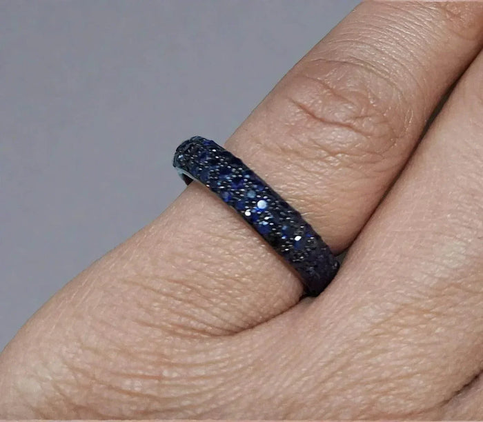 Elegant blue sapphire and diamond eternity ring on finger, luxury fine jewelry
