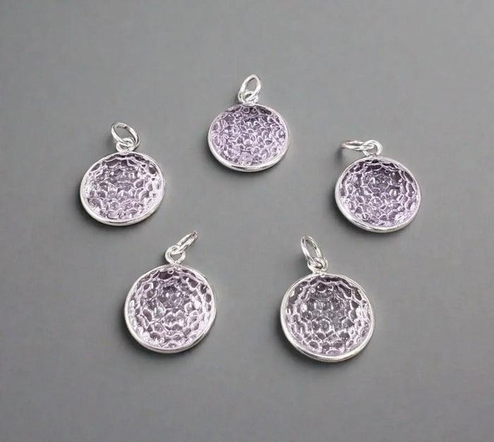 Five round amethyst gemstone pendants with textured silver settings, elegant jewelry accessories