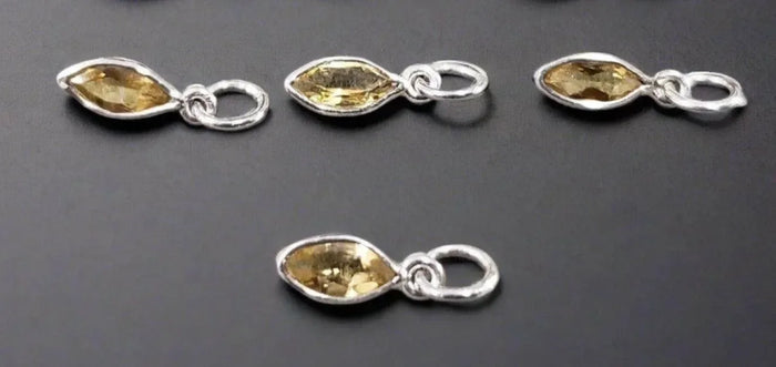 Four marquise-cut citrine gemstone pendants in silver settings, elegant jewelry accessories