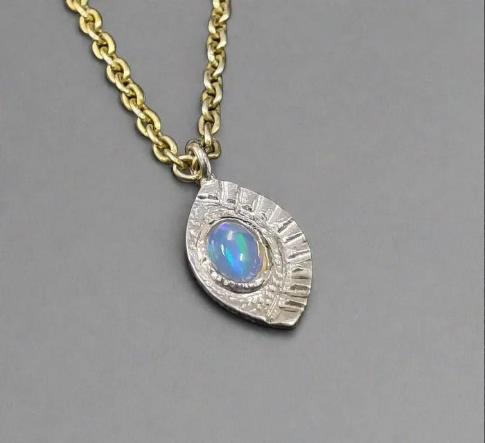 Elegant opal pendant necklace with textured silver setting and gold chain, fine jewelry accessory