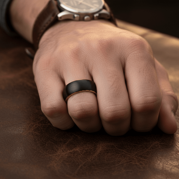 AURELIUS — Lifestyle photo on hand — men's tungsten wedding ring.