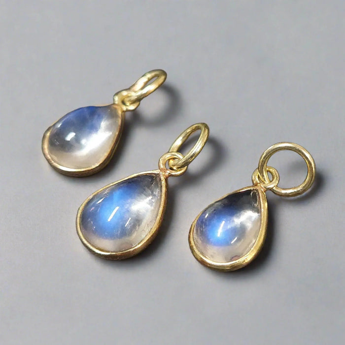 Elegant gold teardrop pendants with blue flash moonstone, perfect for fine jewelry lovers