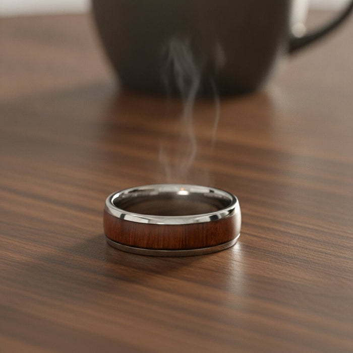 DALBERG silver tungsten carbide domed wedding band with rosewood inlay running around the band and polished finish resting on a walnut wood counter, lifestyle scene