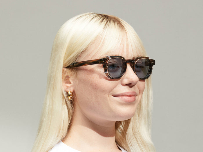 Model is wearing The DOLT CLIP LIMITED EDITION in size 46 in Gold with Blue Tinted Lenses