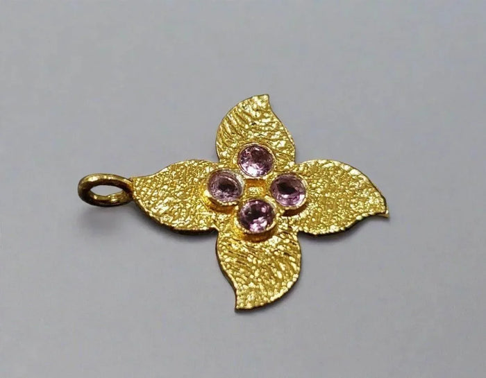 Gold flower pendant with pink gemstones, elegant jewelry accessory