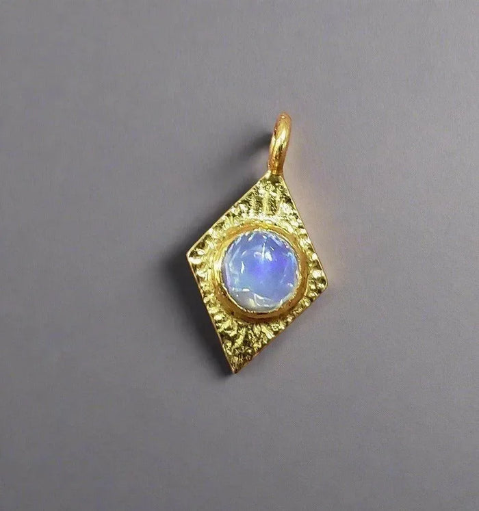 Gold pendant with blue opal gemstone, textured diamond-shaped setting for elegant jewelry