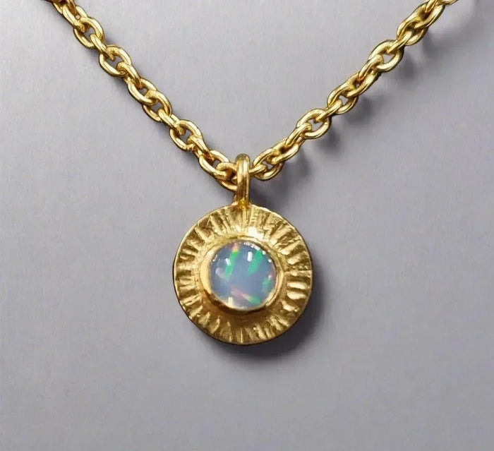 Gold necklace with textured pendant and opal gemstone, elegant jewelry accessory