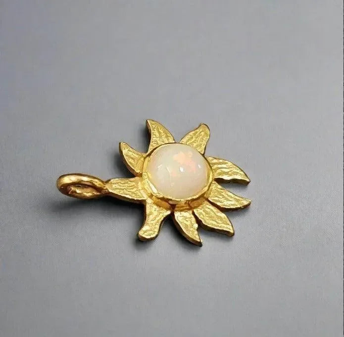 Gold sunburst pendant with opal center, elegant jewelry accessory