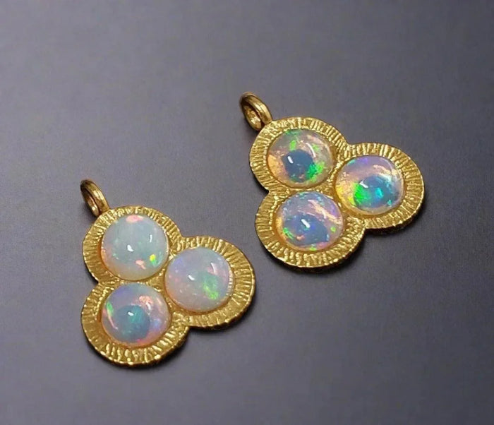 Elegant gold pendants with three opal stones, showcasing iridescent hues for luxury jewelry lovers