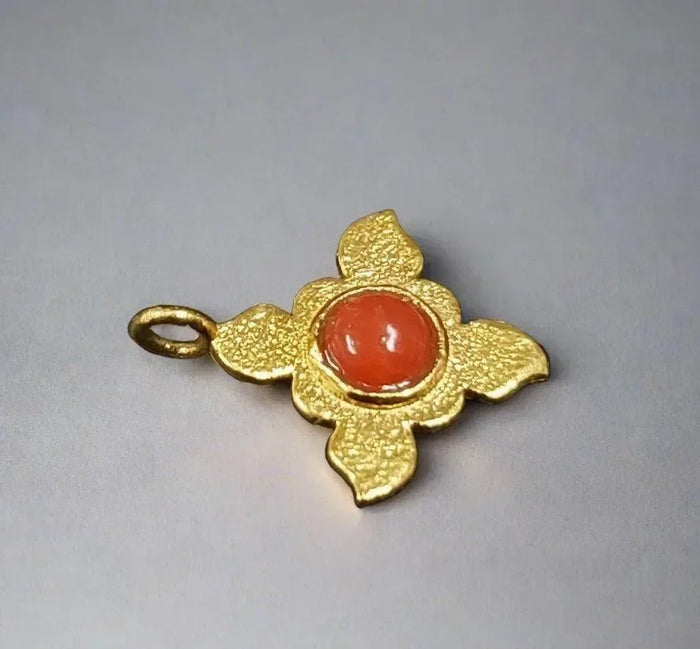 Gold flower pendant with red gemstone, elegant jewelry accessory