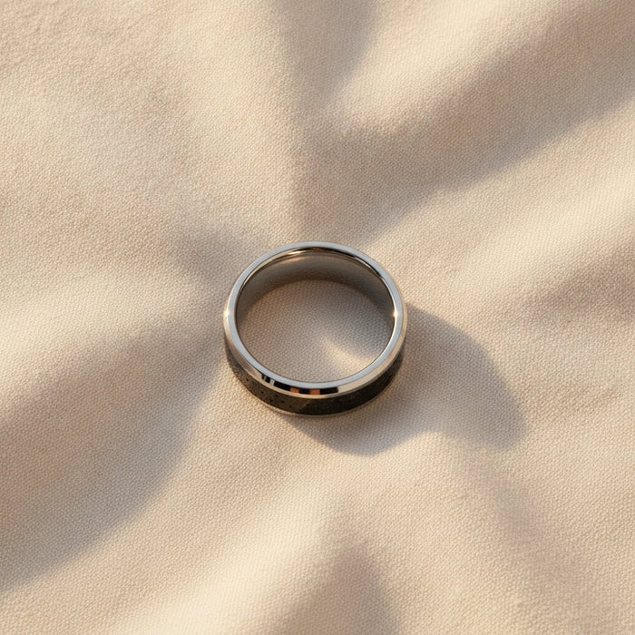 KILAUEA polished silver tungsten wedding band with black and gray lava rock stone inlay running around the band and polished beveled edges macro detail overhead flat lay
