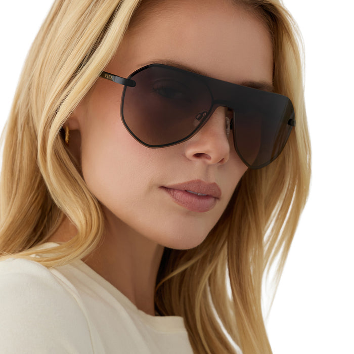 on model - blonde female wearing diff eyewear lonnie oversized aviator sunglasses with a black metal frame and twilight gradient polarized lenses angled view