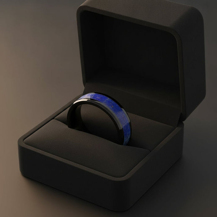 MARLOW polished black ceramic wedding band with blue lapis stone inlay running around the band and polished beveled edges nested in a black velvet ring box, editorial jewelry shot