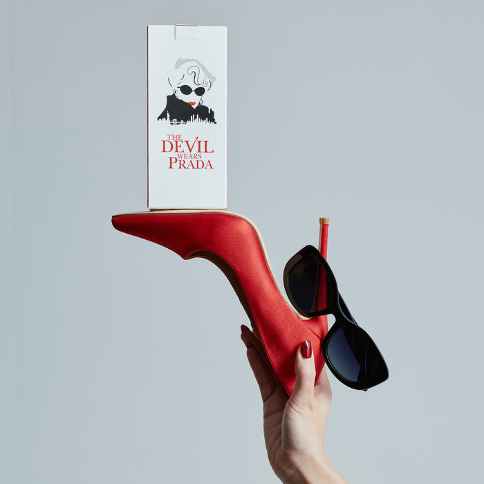 still life - the devil wears prada x diff eyewear mirana sunglasses resting on a red stiletto with a play bill