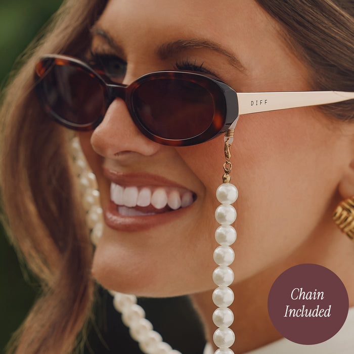 lifestyle - close up of caitlin covington wearing diff eyewear featuring the nancy round sunglasses with a spotted tortoise frame and brown gradient polarized lenses with pearl chain