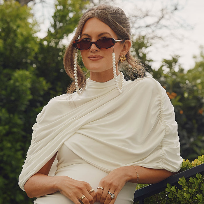 lifestyle - caitlin covington wearing diff eyewear featuring the nancy round sunglasses with a spotted tortoise frame and brown gradient polarized lenses with pearl chain