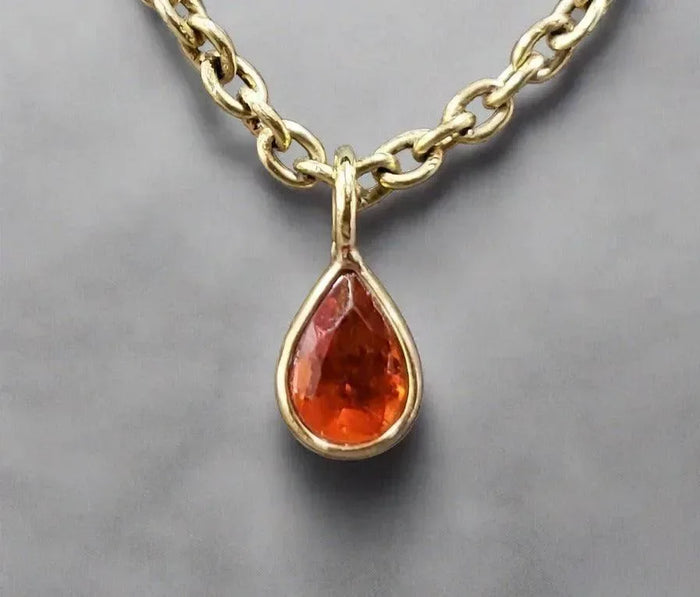 Gold necklace with teardrop orange gemstone pendant, elegant jewelry accessory