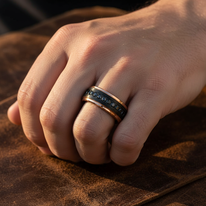 Man wearing PASSINO black tungsten with rose gold edges black CZ eternity ring on ring finger masculine hand