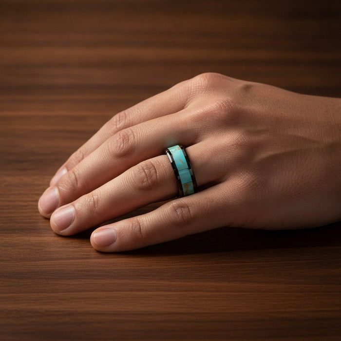 PIETRO polished black ceramic wedding band with light blue turquoise stone inlay running around the band and polished beveled edges worn on man's hand resting on walnut wood, lifestyle photo