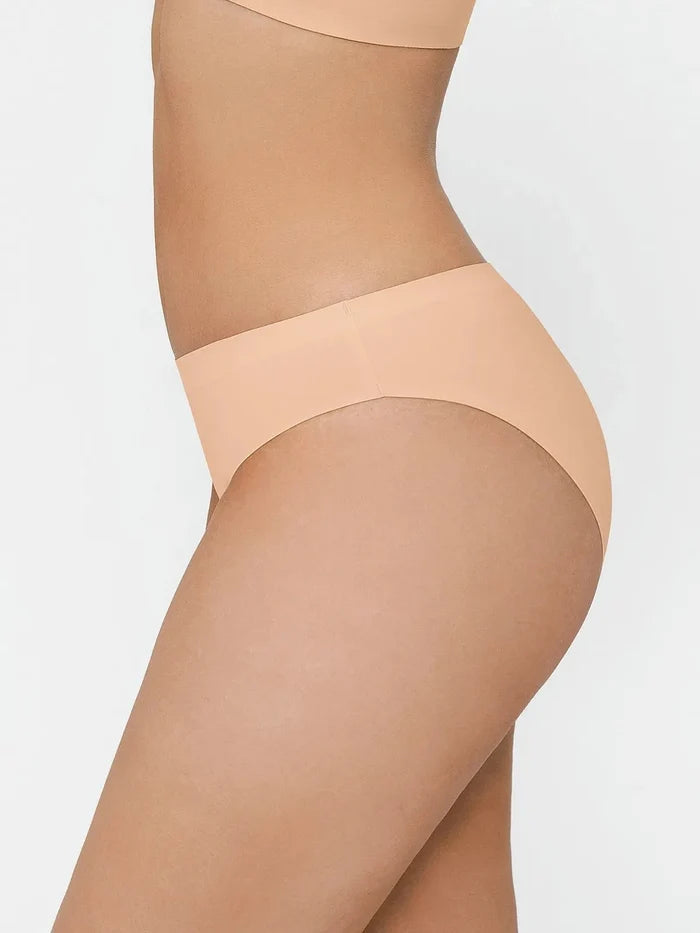 Seamless high-stretch bikini in skin tone on a model, showcasing its smooth fabric and flattering cut.
