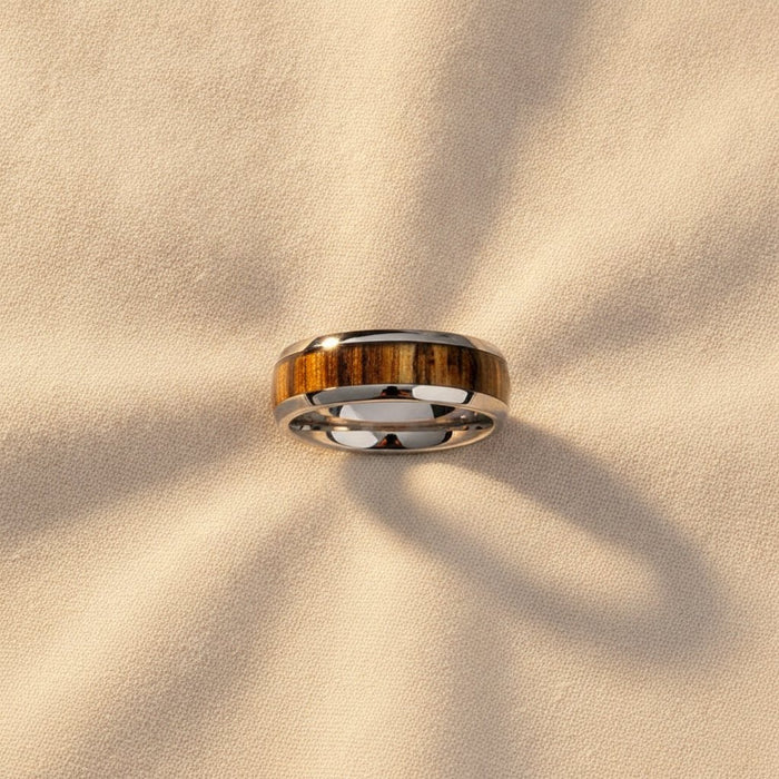 TIGRE silver tungsten wedding band with striped zebra wood inlay running around the band and polished edges macro detail overhead flat lay