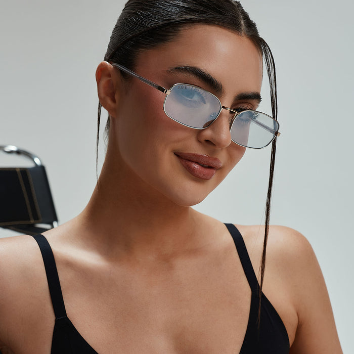 lifestyle - rachael kirkconnell wearing diff eyewear naomi square sunglasses with a trinity silver and gold metal frame and silver lenses angled view